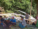 Stripping & flattening bamboo canes to build the teacher's house